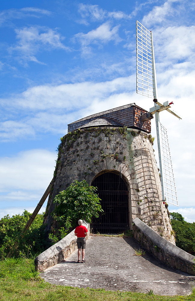 Visitor (man) looks at the remains of a windmill that powered the sugar cane operation at Estate Whim at Frederiksted, St. Croix.