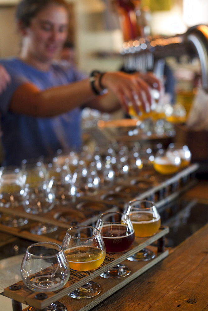 Bartender pours beers for tasting at Allagash Brewery