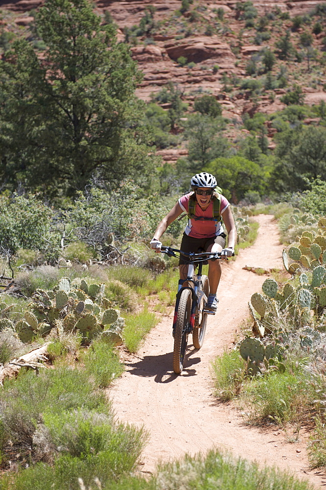 Woman rides the Submarine Rock Loop in South Sedona, Arizona. The trail has everything from slickrock to single track to stairs that lead to Submarine Rock.