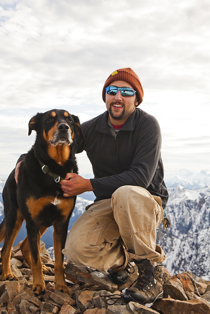 Portrait of a man and his dog on the summit of Frosty Peak, BC, Canada.