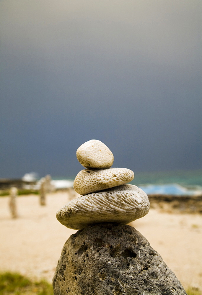 Stacks of rocks are placed on a beach for good luck under a threatening sky, Jamaica