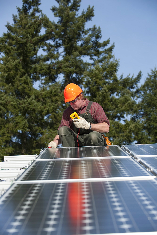 A technician measures the electricity generated by a photovoltaic panel, United States of America