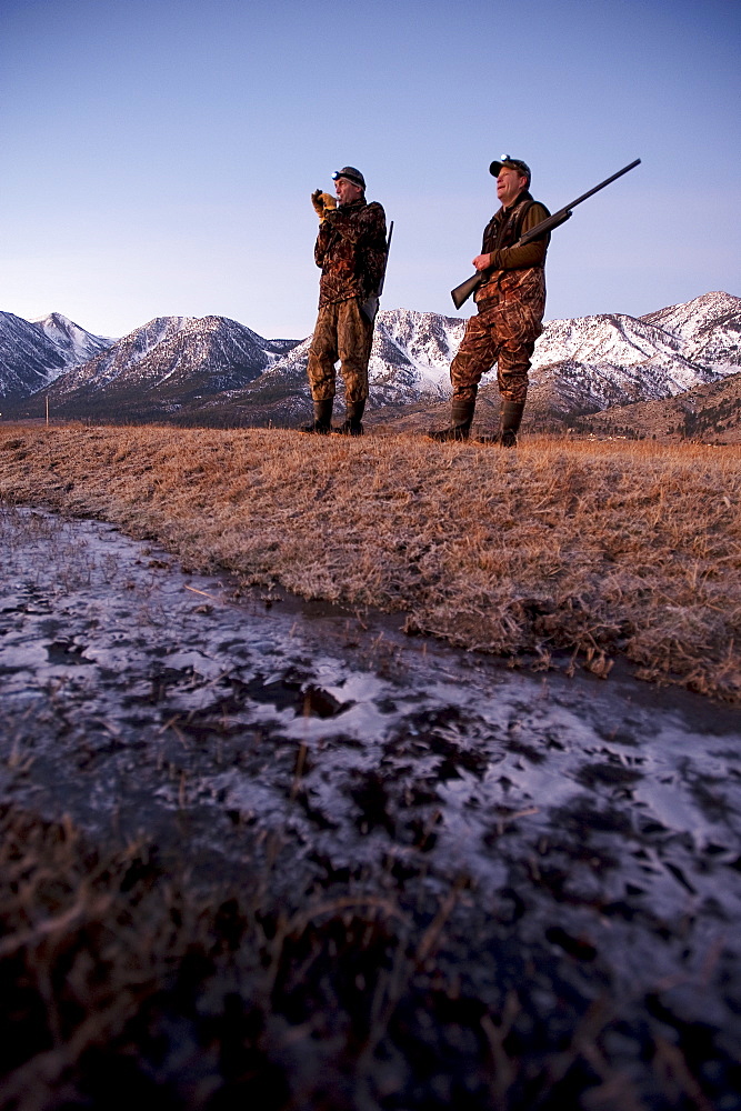 Brad Jackson uses a call as Corey Funk keeps his eyes open for geese as the two men hunt in the early morning in Carson City, NV, United States of America