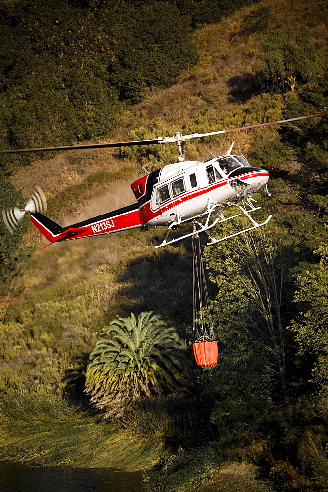 Helicopters pick up water from a reservoir while fighting wildfires in Santa Barbara, California, United States of America