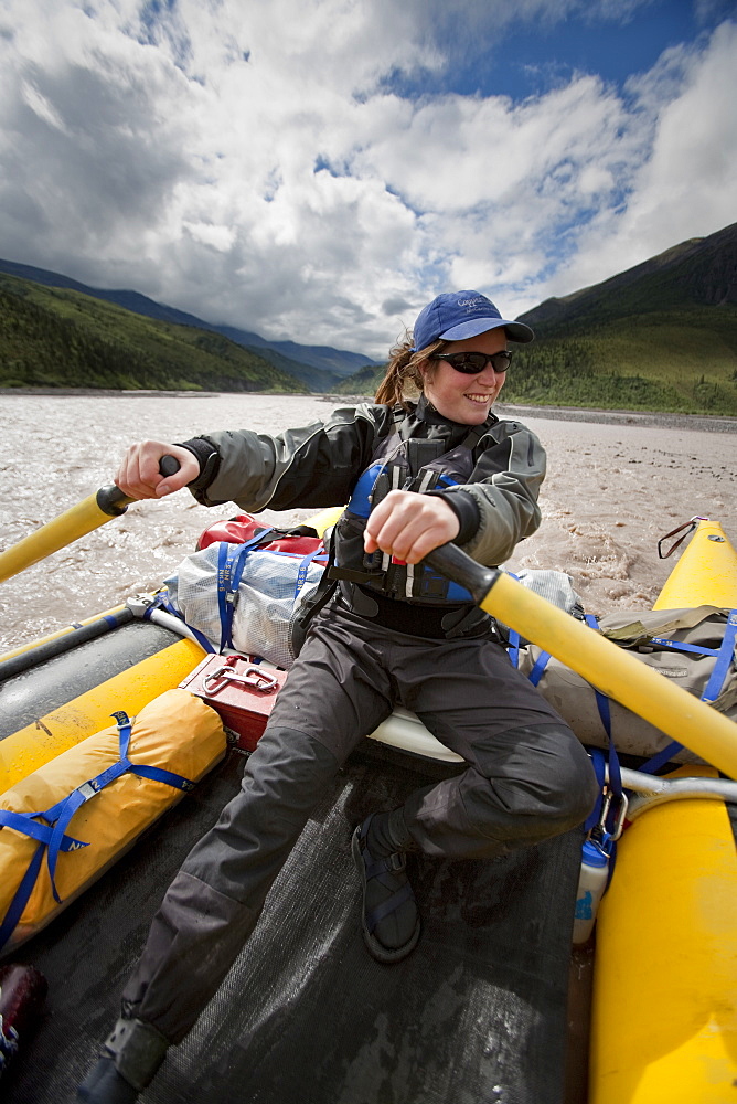 A woman rowing a raft down the Jacksina river, Wrangell-St. Elias National Park, Alaska.