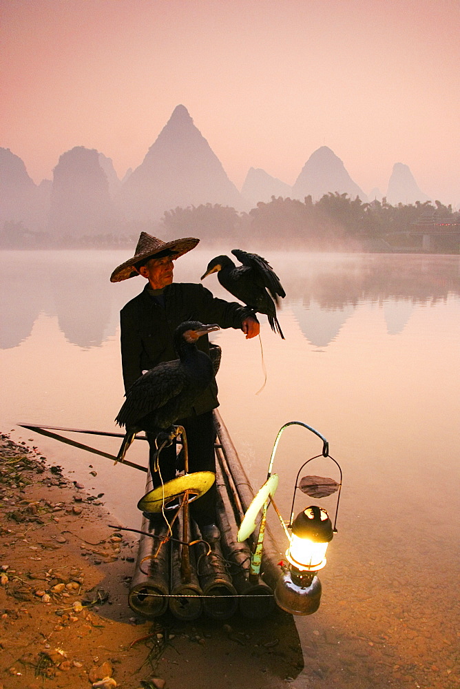 Chinese fisherman fishing in Li Jang River with cormorant birds, Guilin, China