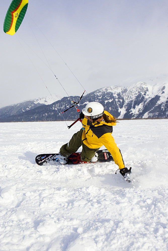 A mid adult man enjoys the outdoors while snow kiting in Alaska.