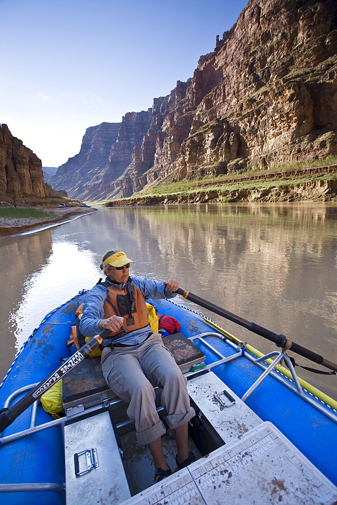 A woman rowing an inflatable raft down the Colorado river, Utah.