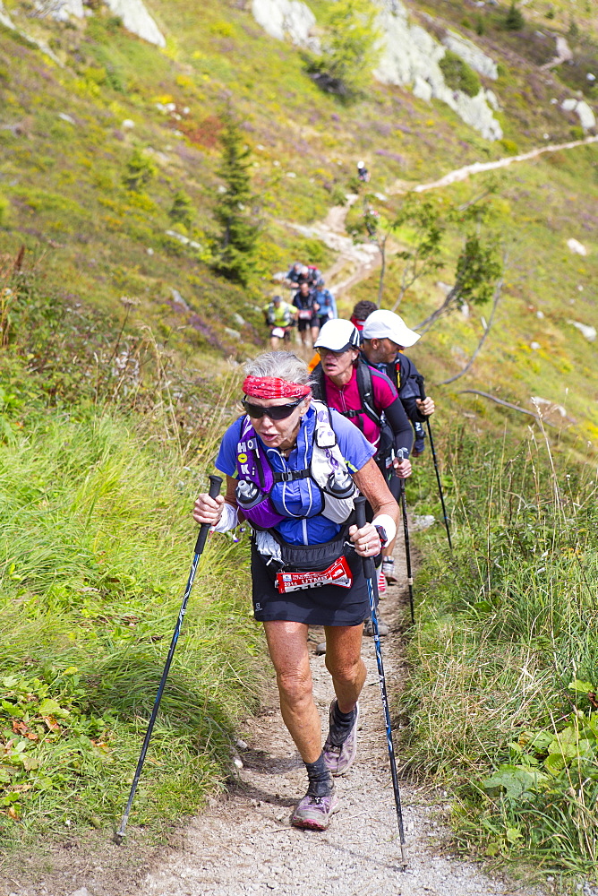 An elderly woman is running in the hills of Chamonix. She is close to finishing the extremely exhausting UTMB race. The Ultra-Trail du Mont-Blanc (also referred to as UTMB) is a single-stage mountain ultramarathon. It takes place once a year in the Alps, across France, Italy and Switzerland. The distance is approximately 166 kilometres (103 mi), with a total elevation gain of around 9,600 m. It is widely regarded as one of the most difficult foot races in Europe. It's certainly one of the largest with over two thousand starters. The combined participation in all of the events is approaching 10 thousand runners. While the best runners complete the loop in slightly more than 20 hours, most runners take 30 to 45 hours to reach the finish line.