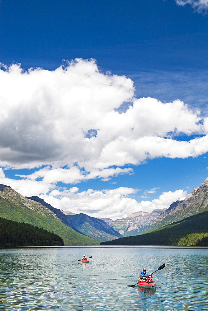 Two Kayakers Kayaking On Bowman Lake In Glacier National Park