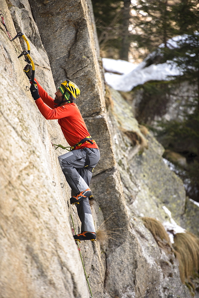 Male Climber Ice Climbing And Drytooling In Ceresole Reale Ice Park