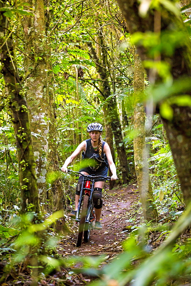 Female Mountain Biker Riding In Forest Trail Of Bali, Indonesia