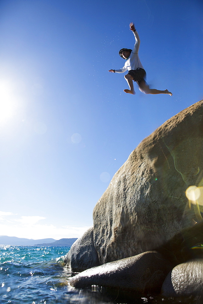 Man Jumping On Rock Into The River At Sand Harbor State Park