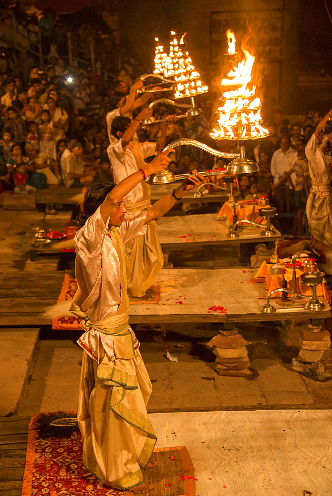 Hindu priests raise large aarti lamps during Ganga Aarti at Dashaswamedh ghat, Varanasi, Uttar Pradesh, India