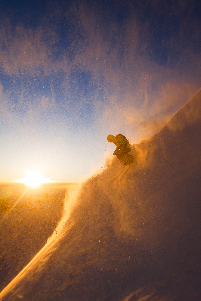 Bryce Philips Surrounded By Snow Powder During Skiing On Snowy Landscape During Sunset