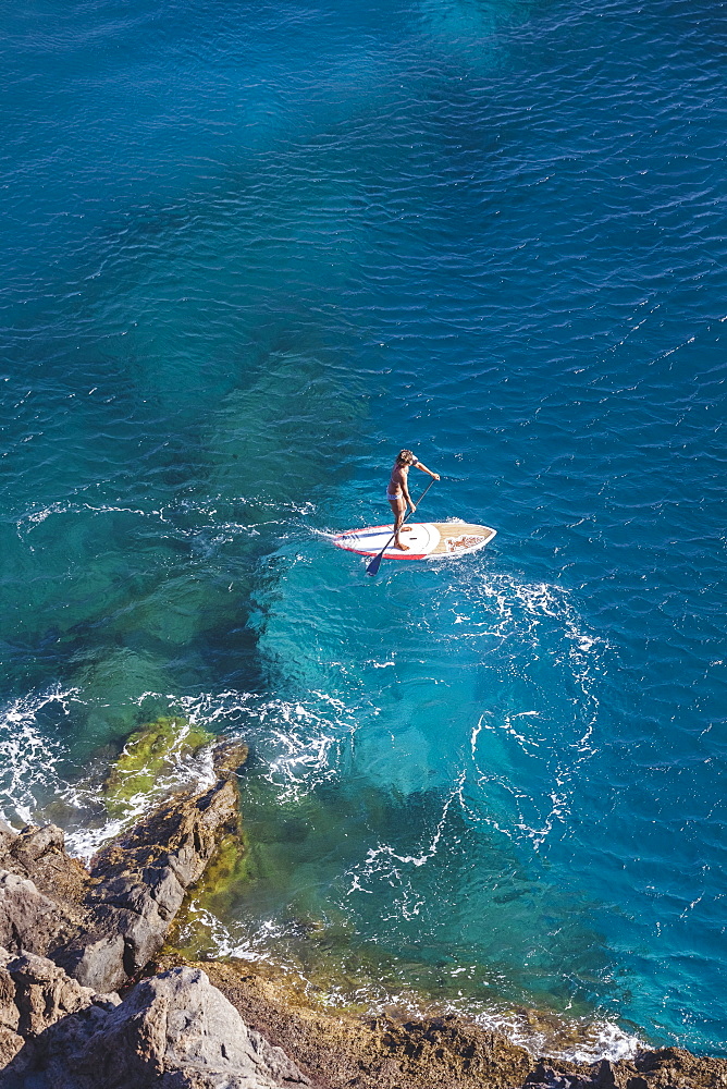SUP girl enjoying in a beautiful sea