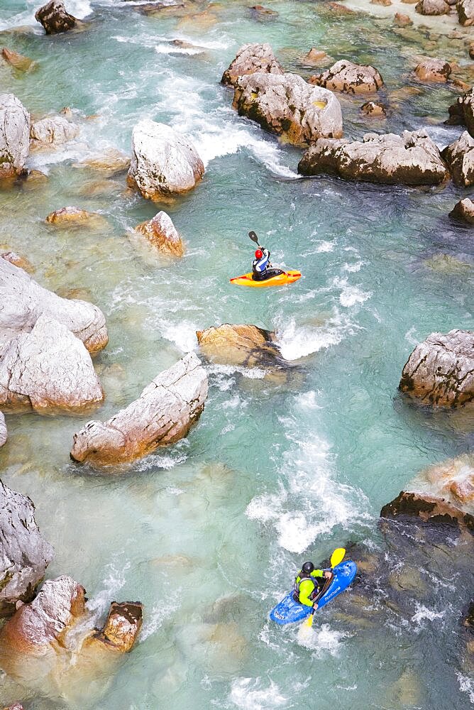 Male kayakers on green colored Soca river near Bovec, Slovenia