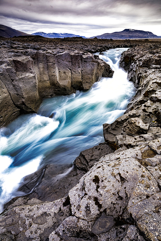 Scenic landscape of glacial meltwater running through andesite lava river channel in highlands of Iceland