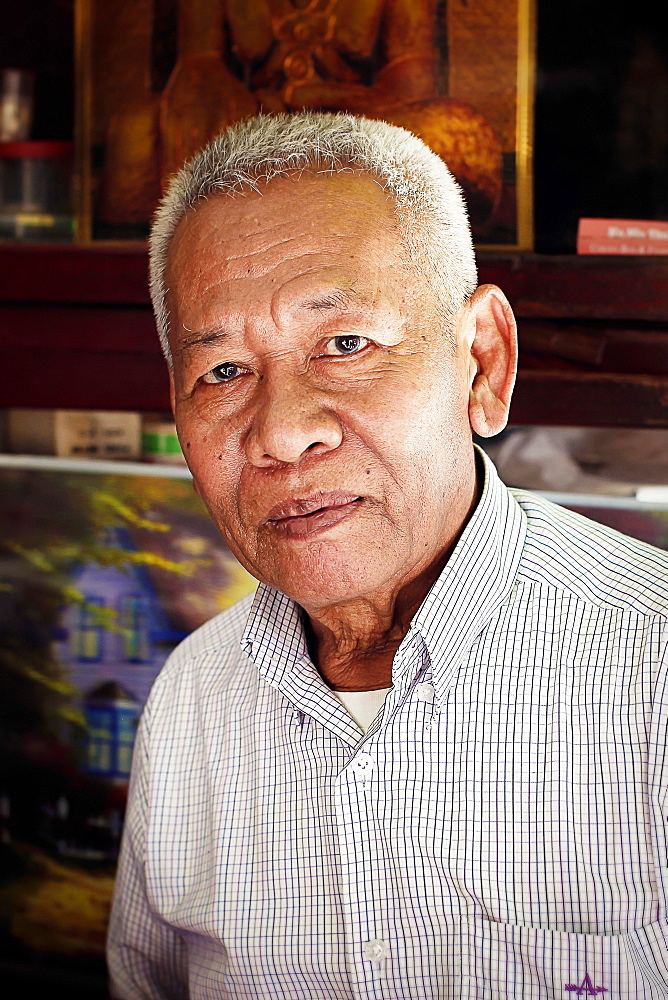 Head and shoulders portrait of mature man with gray hair looking at camera, Kerala, India