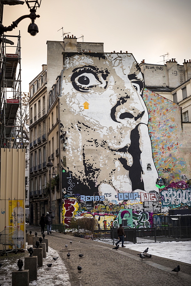 Mural of human face with finger on lips on wall of apartment block, The Marais, Paris