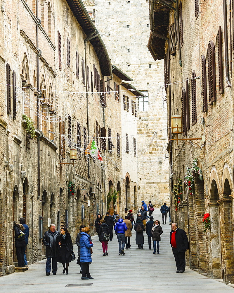 Tourists in San Gimignano, a small walled medieval hill town in the province of Siena, Tuscany, north-central Italy. Known as the Town of Fine Towers, San Gimignano is famous for its medieval architecture, unique in the preservation of about a dozen of its tower houses, which, with its hilltop setting and encircling walls