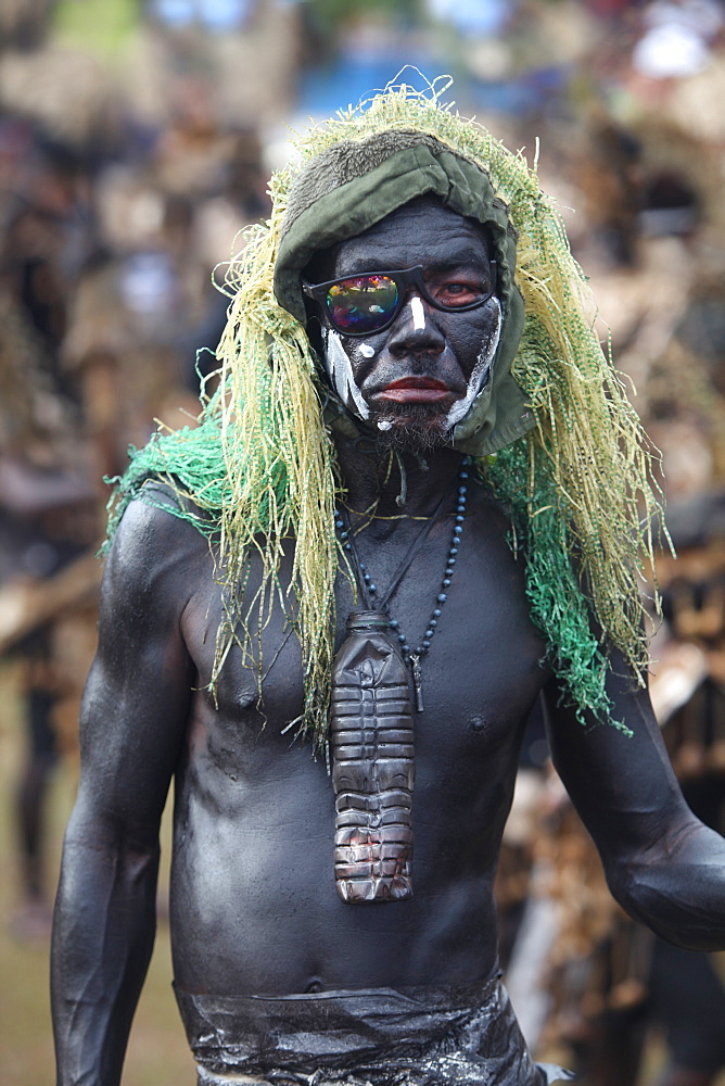 Funny man with skin painted black and green hairpiece on blurred background at Ati Atihan festival, Kalibo, Aklan, Panay Island, Philippines