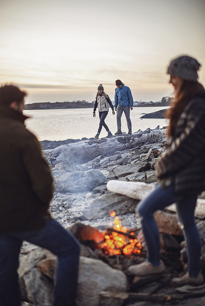 Group ofÂ friendsÂ aroundÂ beachsideÂ campfire, Peaks Island, Maine, USA