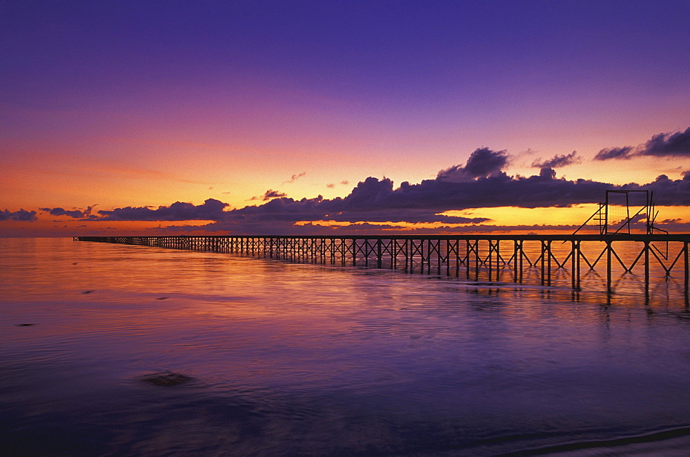 Long Pier In Ocean At Sunset