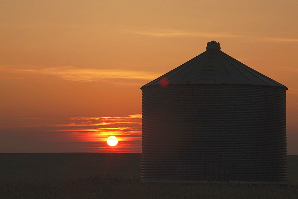 Silhouette Of Grain Bin At Sunrise