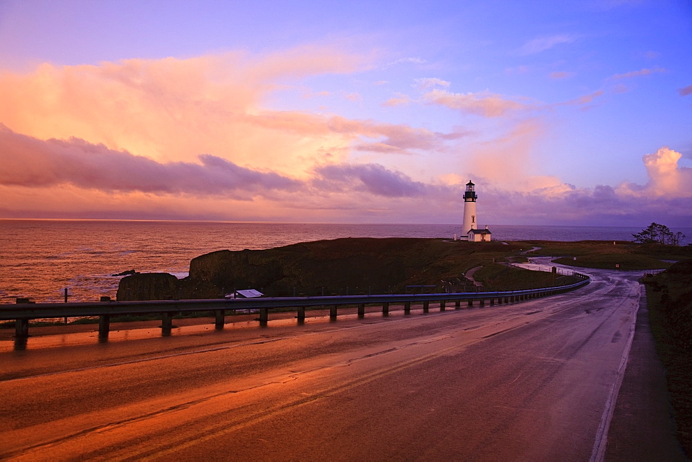 A Road And A Lighthouse Along The Coast At Sunset