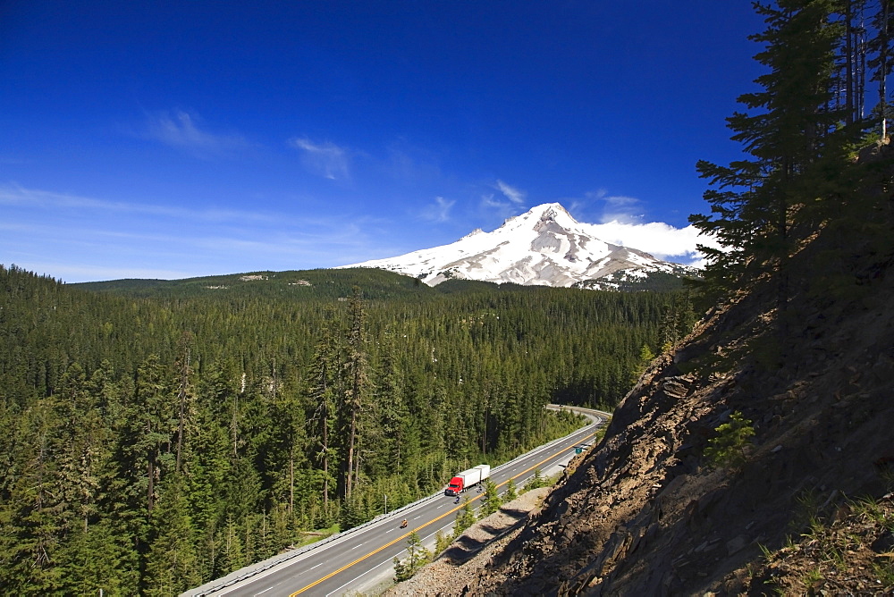 A Transport Truck On The Highway Traveling Through The Mountains