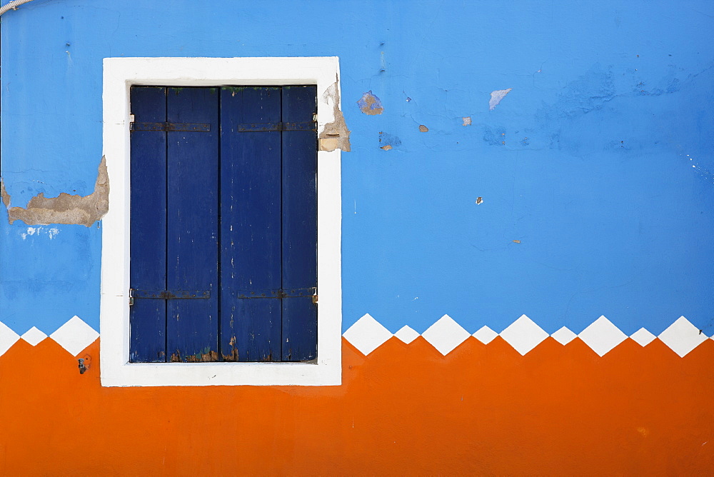 Paint Peeling Off Of A Decorative Exterior Wall And A Closed Shutters On A Window, Burano, Venezia, Italy