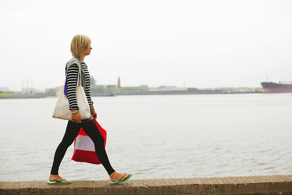 A Young Woman Walking On The Wall By The Harbor, Houten, The Netherlands