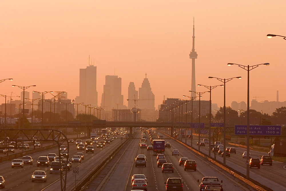 View Of Toronto Skyline From Above Queen Elizabeth Way Highway During Start Of Rush Hour Traffic, Toronto, Ontario, Canada.