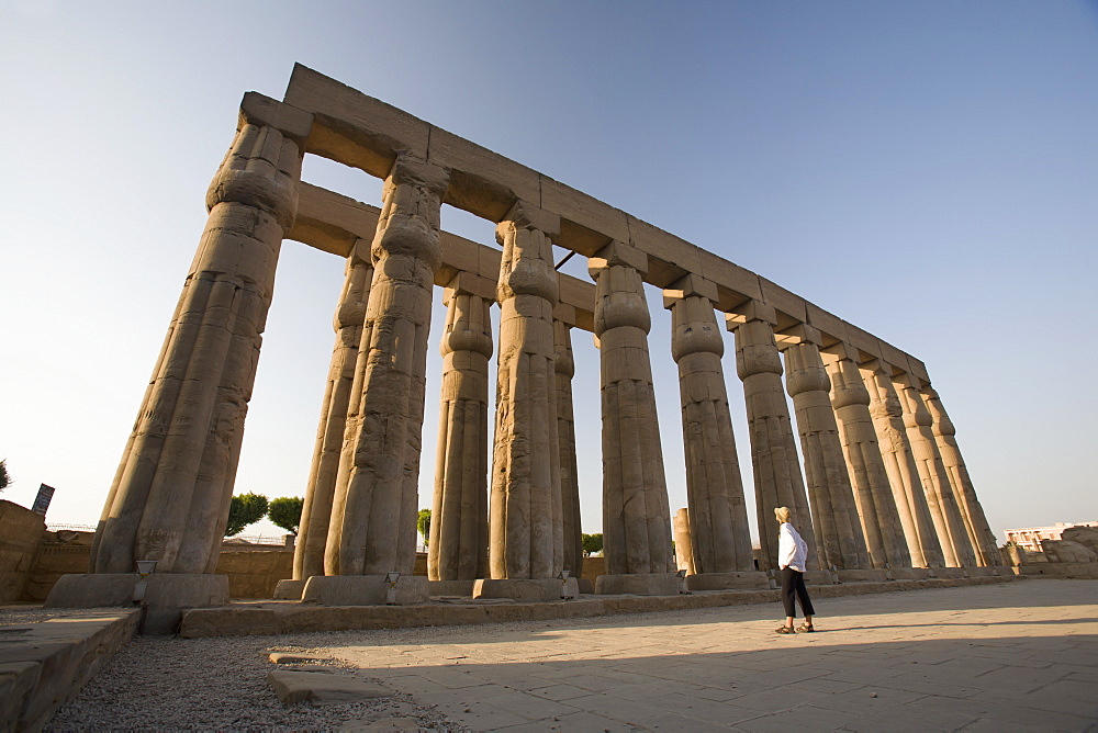 A Woman Tourist Looks Up At The Columns In The Luxor Temple, Luxor, Egypt