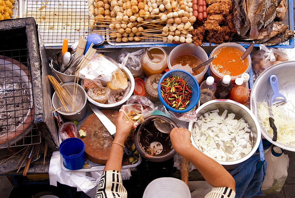 Thailand, Bangkok, View From Above Of A Street Food Stall With Vendor Prepping Food.