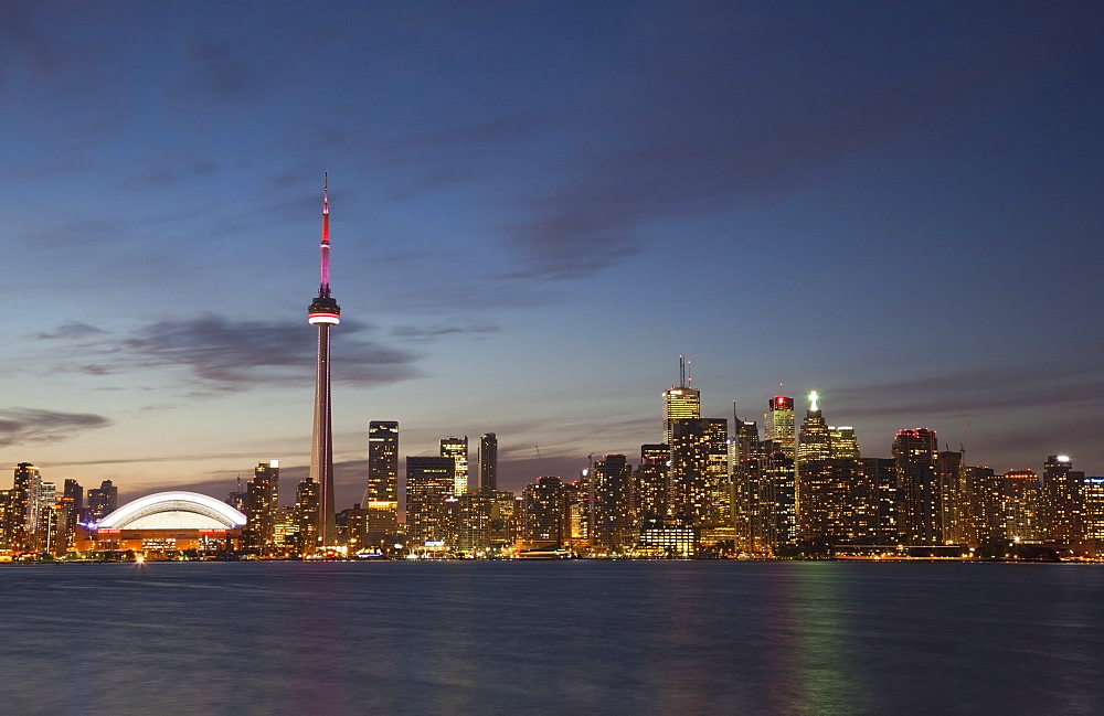 View over lake ontario of the downtown toronto skyline and cn tower illuminated at dusk, Toronto ontario canada