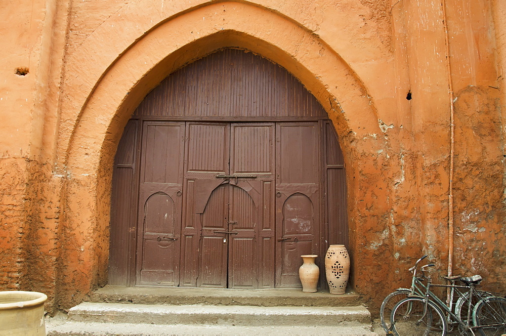 Wooden Door Of A House With An Archway And Two Bikes Parked Outside, Marrakech Morocco