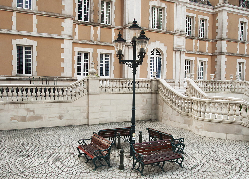 Wooden benches around a lamp post outside of a building, Tokyo japan