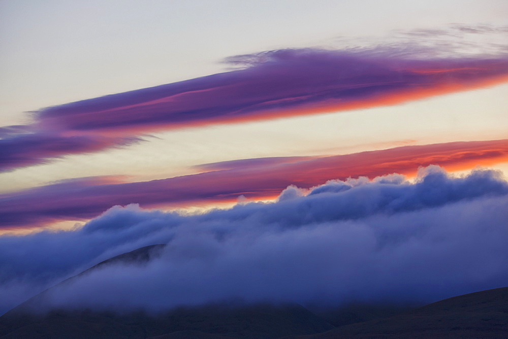 The morning light illuminates clouds above the mist covering richardson mountains along the dempster highway, Yukon canada