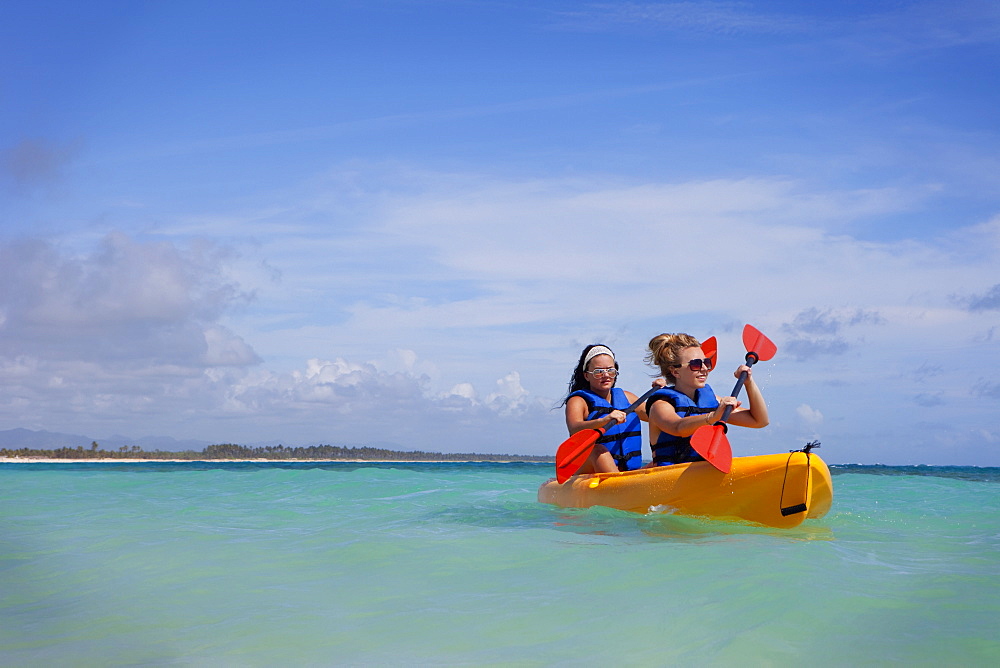 Two Women In Lifejackets Paddling In A Yellow Boat, Punta Cana, La Altagracia, Dominican Republic