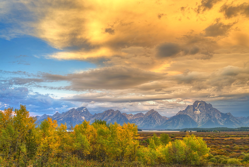 Glowing Golden Clouds Over Rugged Mountains In Grand Teton National Park, Wyoming, United States Of America