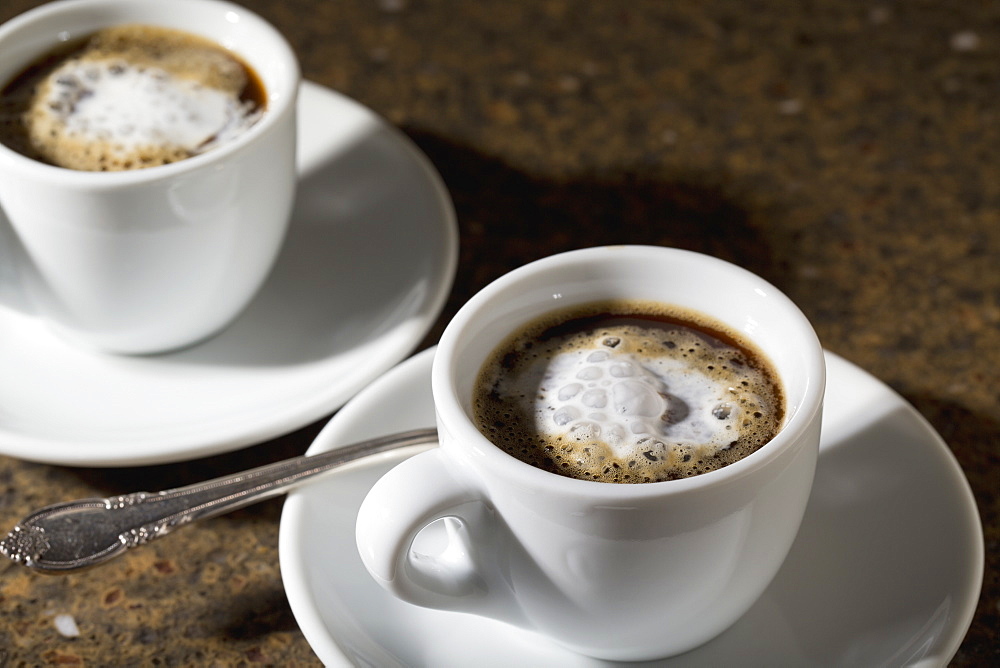 Close Up Of Two Espresso Coffee Cups And Saucers With Foam And Coffee On Granite Counter, Calgary, Alberta, Canada