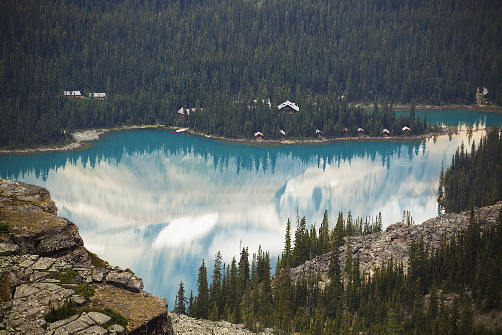 Alpine Lake Framed By Shoreline And Mountain Cliffs And Reflecting The Mountains, British Columbia, Canada