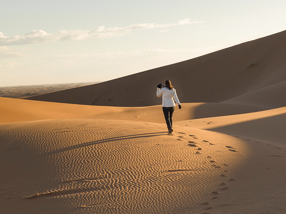 A woman walking on a sand dune, Sous-massa-draa morocco