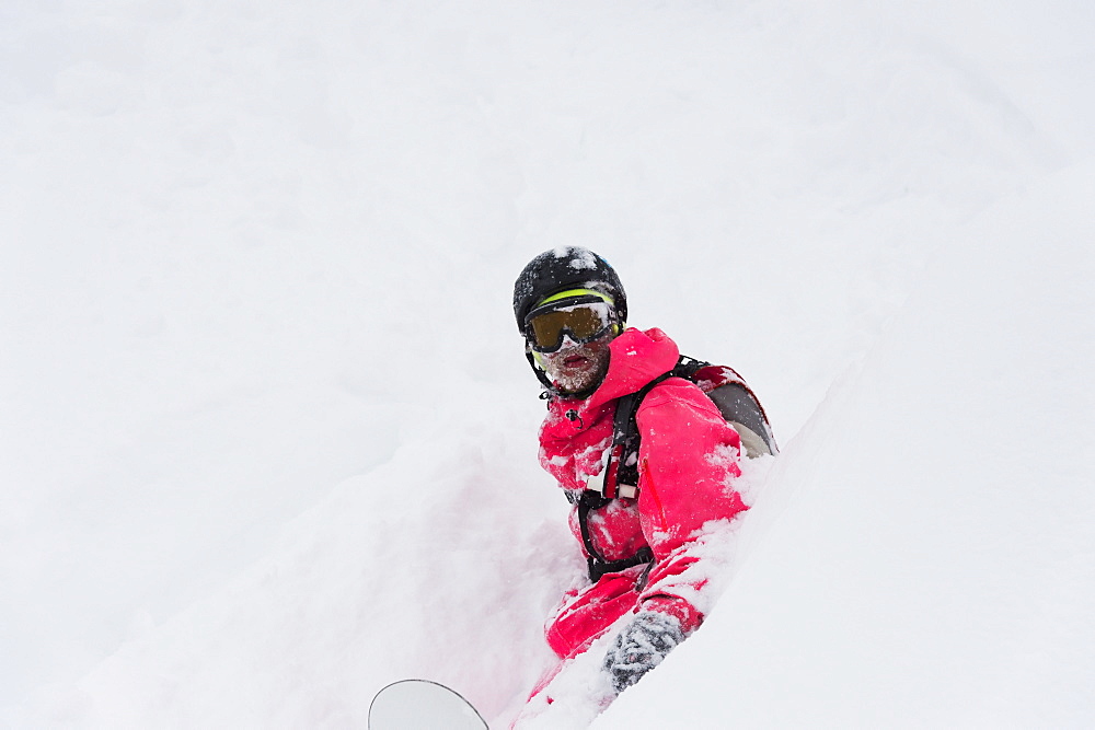 Snowboarder Sitting In Deep Powder Snow, St. Moritz, Graubunden, Switzerland