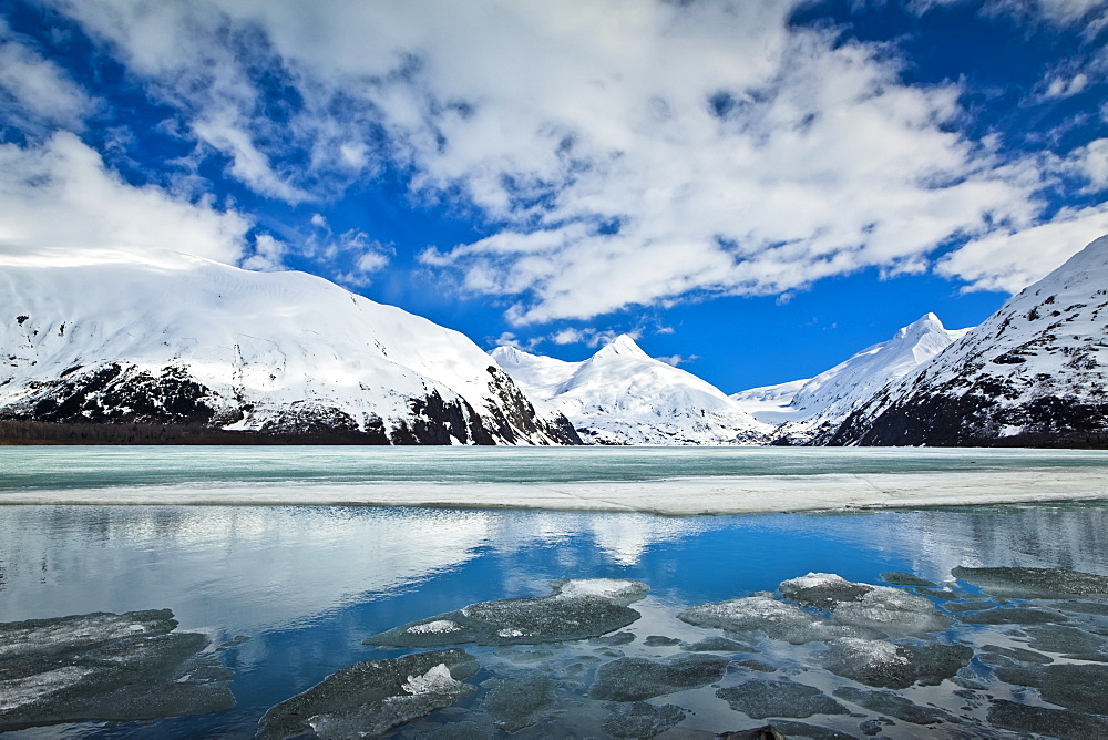 Snow Covered Mountain Peaks Reflected On The Half Frozen Portage Lake, Chugach National Forest, Alaska, United States Of America