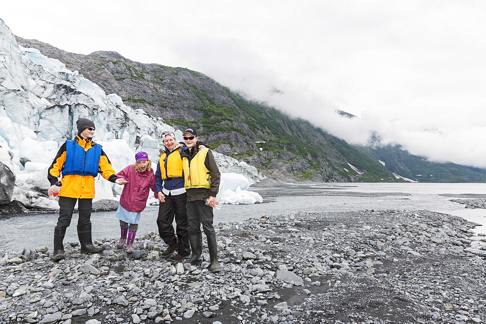 A Family Poses In Front Of Shoup Glacier And Chugach Mountains, Shoup Bay State Marine Park, Prince William Sound, Valdez, Alaska, United States Of America