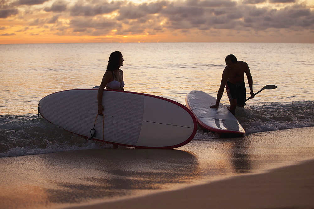 Couple Paddleboarding At Sunset, Caribbean