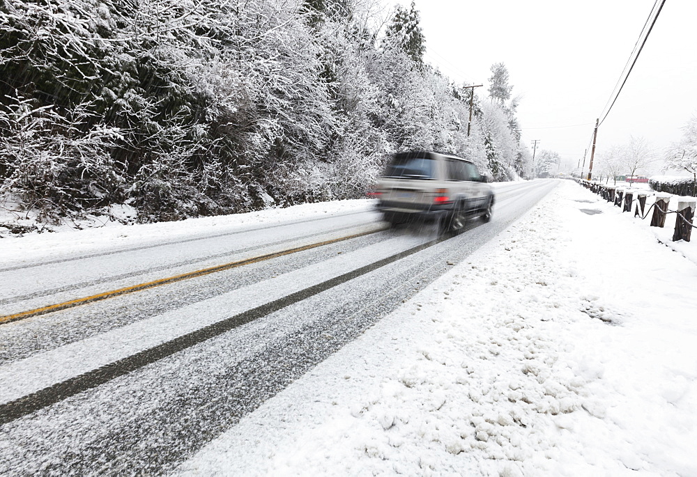 A Vehicle Makes Its Way On Snow Covered Roads On Vancouver Island, Duncan, British Columbia, Canada